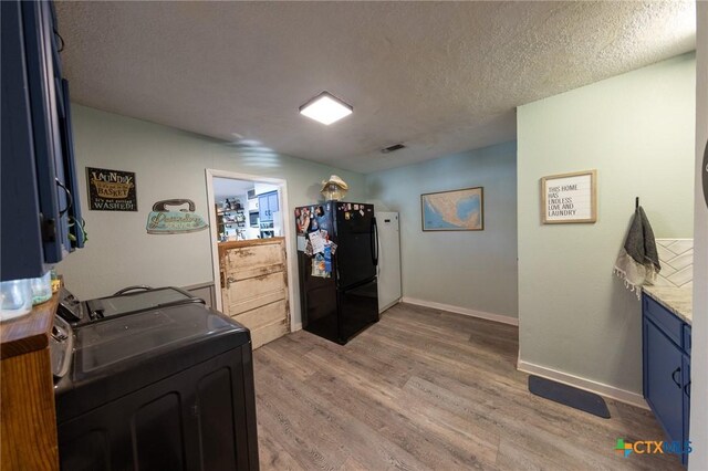 108 Elaine St, Victoria, TX 77904 - washroom with a textured ceiling, light wood-type flooring, visible vents, cabinet space, and washer and dryer
