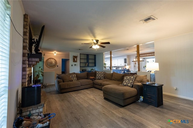 108 Elaine St, Victoria, TX 77904 - living area featuring visible vents, baseboards, a ceiling fan, wood finished floors, and a brick fireplace