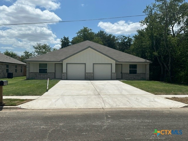 view of front of home featuring a garage and a front lawn