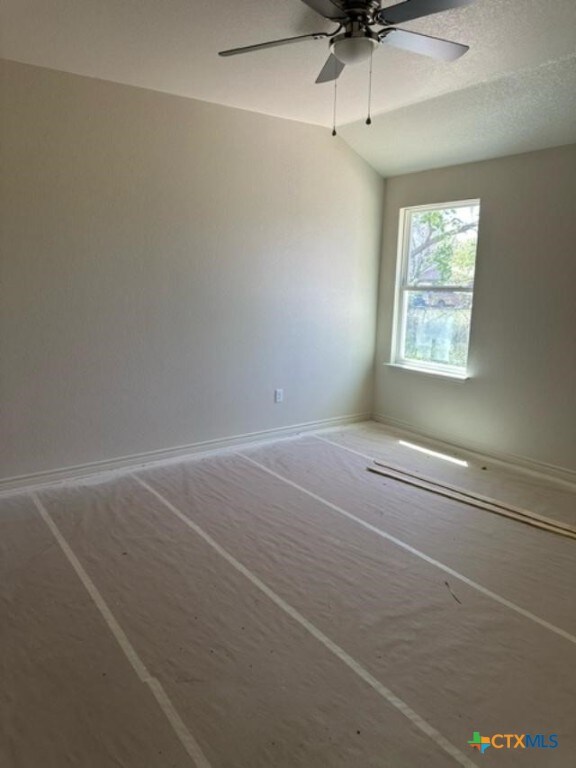 unfurnished room with vaulted ceiling and ceiling fan