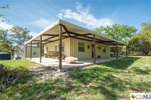 rear view of property featuring a yard and a patio area