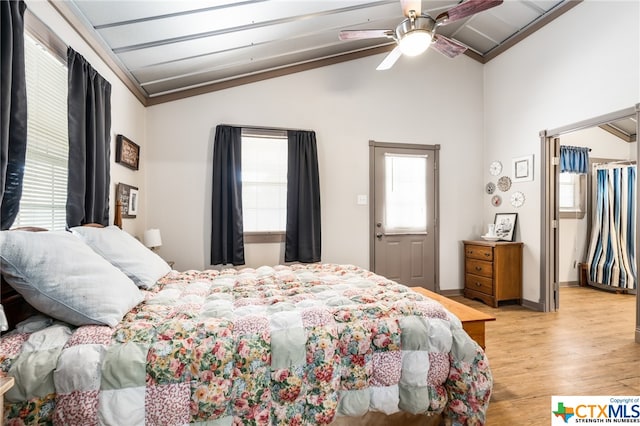 bedroom featuring light hardwood / wood-style floors, multiple windows, vaulted ceiling, and ceiling fan