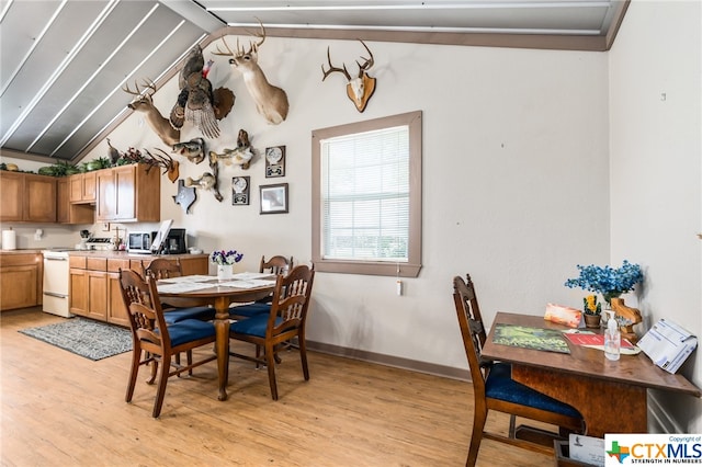 dining room featuring light wood-type flooring and lofted ceiling