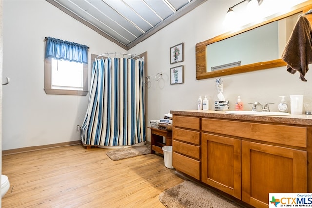 bathroom with hardwood / wood-style flooring, crown molding, toilet, and lofted ceiling