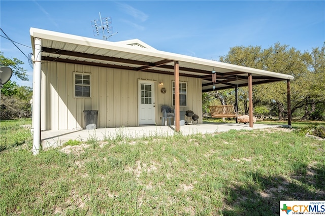 rear view of property featuring a yard and a patio area