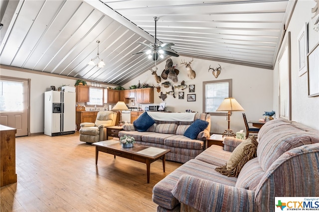 living room with light wood-type flooring, lofted ceiling with beams, ceiling fan, and sink