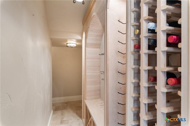 wine room featuring stone finish flooring and baseboards