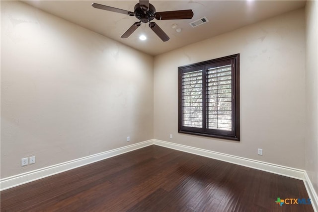 unfurnished room featuring dark wood-style floors, visible vents, ceiling fan, and baseboards