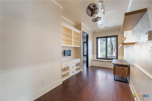 interior space with a wainscoted wall, dark wood-type flooring, visible vents, and crown molding