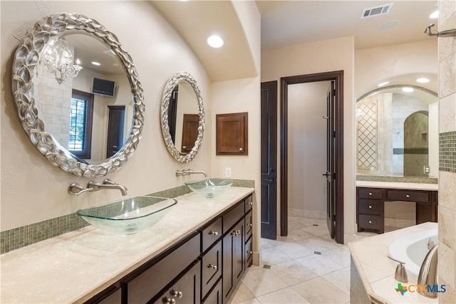 full bathroom featuring double vanity, tile patterned flooring, visible vents, and a sink