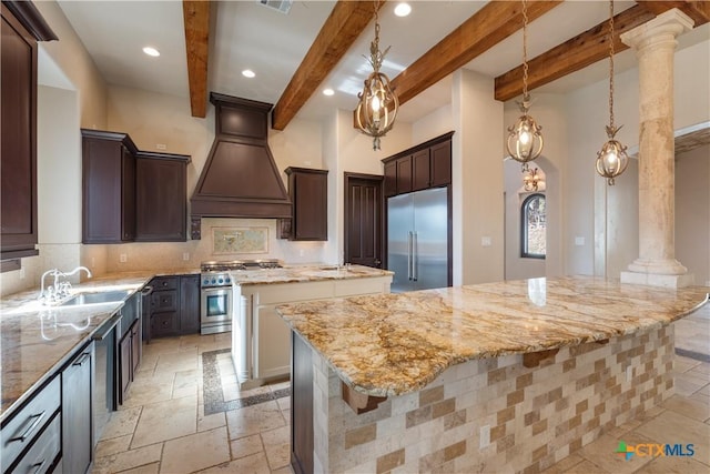 kitchen with premium appliances, custom exhaust hood, stone tile flooring, a sink, and a kitchen island