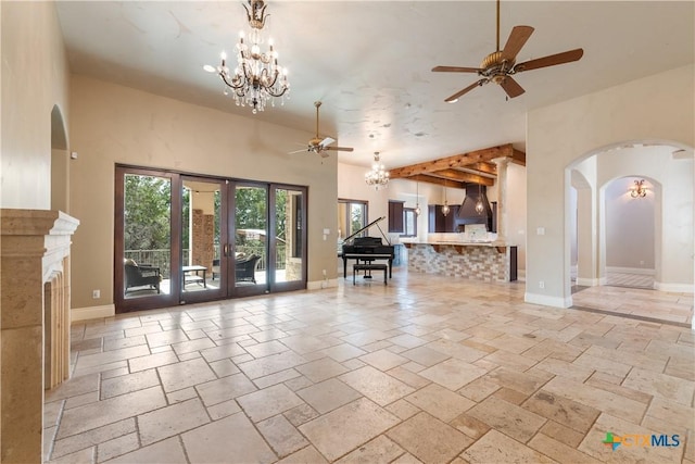 unfurnished living room featuring baseboards, french doors, ceiling fan with notable chandelier, and stone tile floors