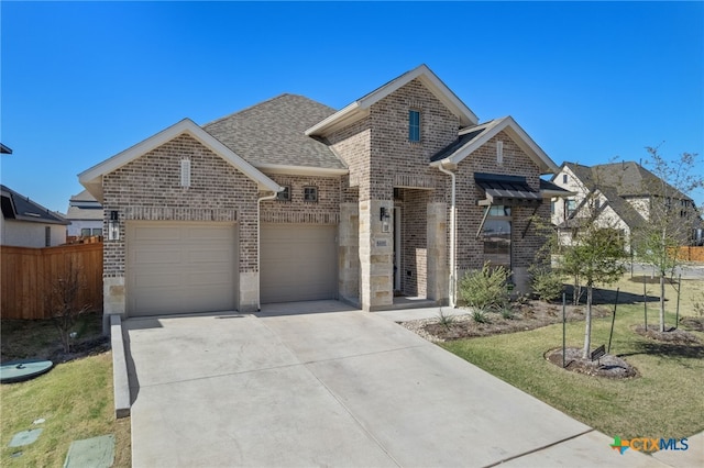 view of front of home featuring an attached garage, brick siding, a shingled roof, fence, and driveway