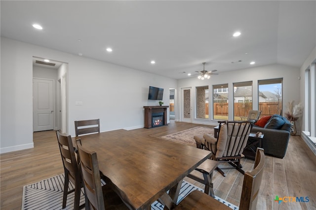 dining room featuring recessed lighting, visible vents, light wood-style flooring, a glass covered fireplace, and baseboards