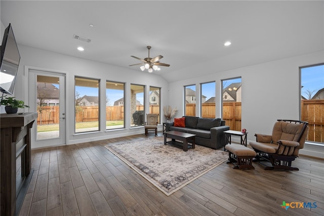 living room with dark wood-style floors, visible vents, and plenty of natural light