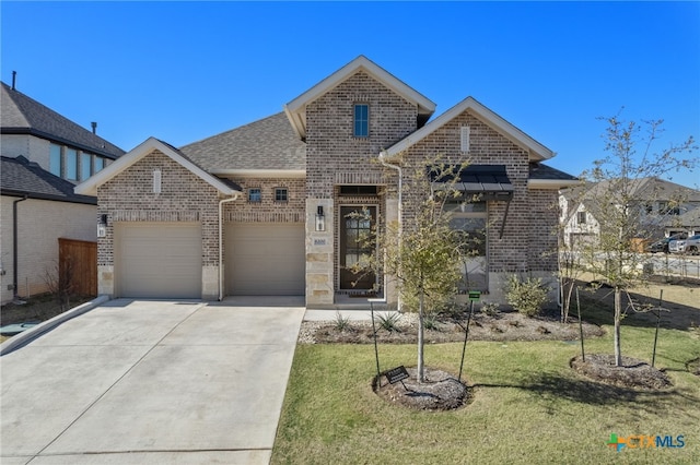 view of front of property with brick siding, a shingled roof, a garage, driveway, and a front lawn