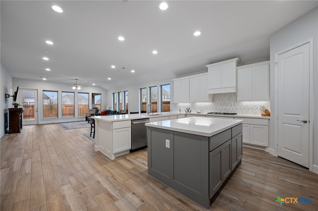 kitchen featuring open floor plan, light countertops, gray cabinets, a center island, and dishwasher