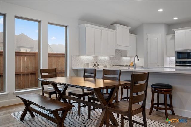 dining space featuring light wood-style flooring, baseboards, and recessed lighting