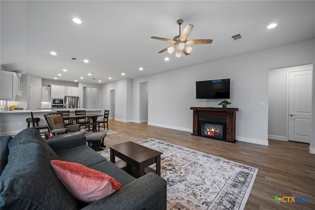 living area featuring baseboards, visible vents, wood finished floors, and recessed lighting