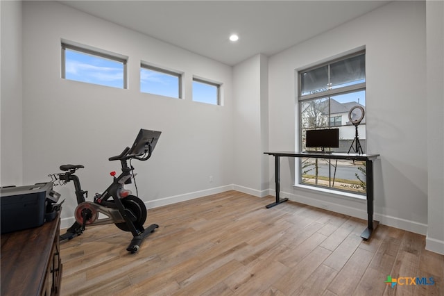 workout room with plenty of natural light, light wood-style flooring, baseboards, and recessed lighting