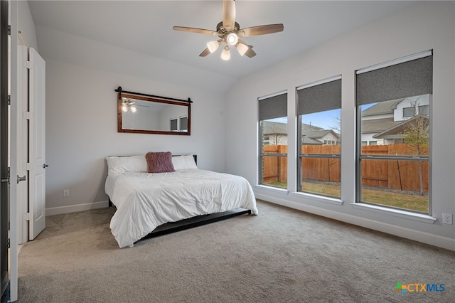 bedroom with carpet, baseboards, vaulted ceiling, and a ceiling fan