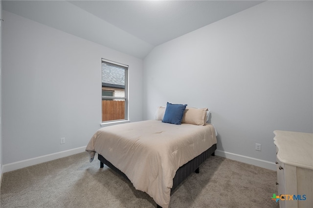 bedroom with vaulted ceiling, carpet, and baseboards