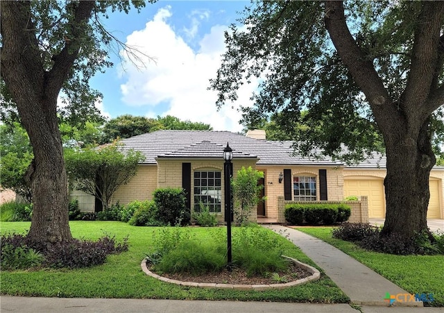 114 Berkshire Ln, Victoria, TX 77904 - ranch-style home featuring an attached garage, brick siding, a front yard, and a tiled roof