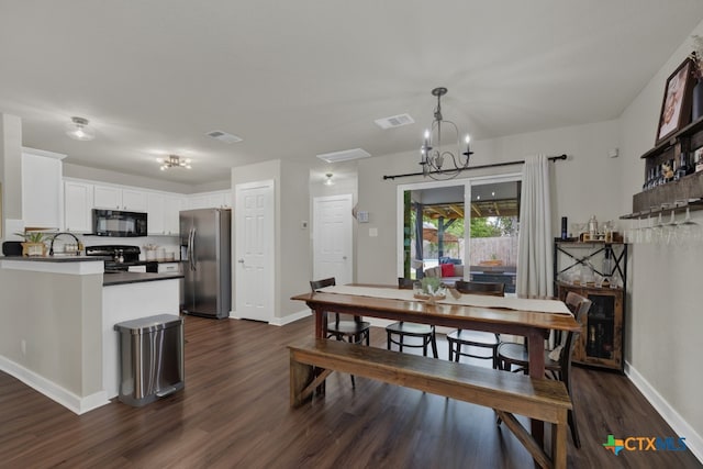 dining room with a notable chandelier and dark hardwood / wood-style flooring