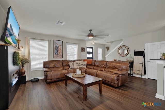 living room featuring a healthy amount of sunlight, dark wood-type flooring, and ceiling fan