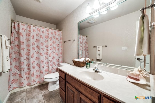 bathroom with tile patterned flooring, vanity, and toilet