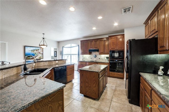 kitchen with sink, stone counters, hanging light fixtures, black appliances, and a kitchen island