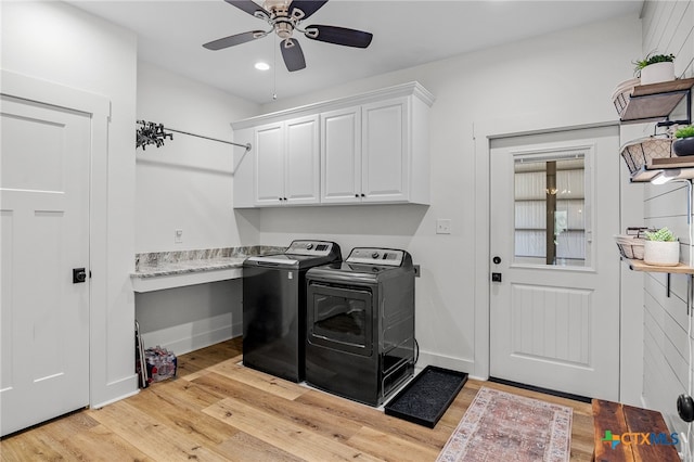 clothes washing area with cabinets, light hardwood / wood-style floors, ceiling fan, and washing machine and clothes dryer