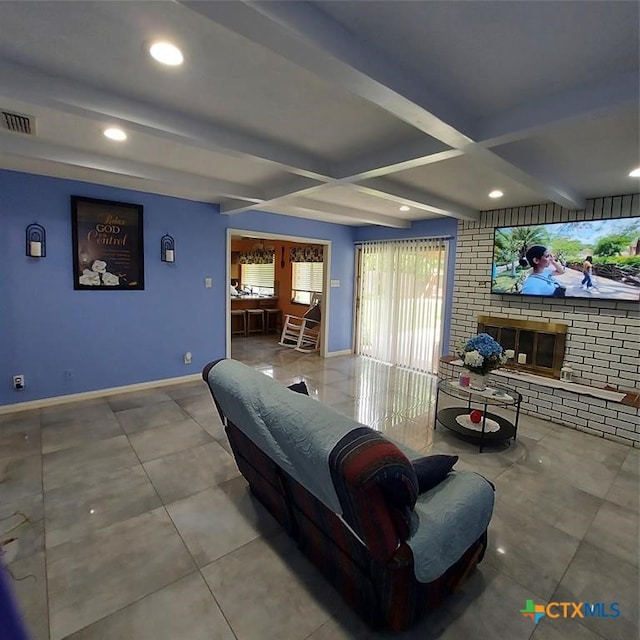 living room featuring beamed ceiling and a brick fireplace