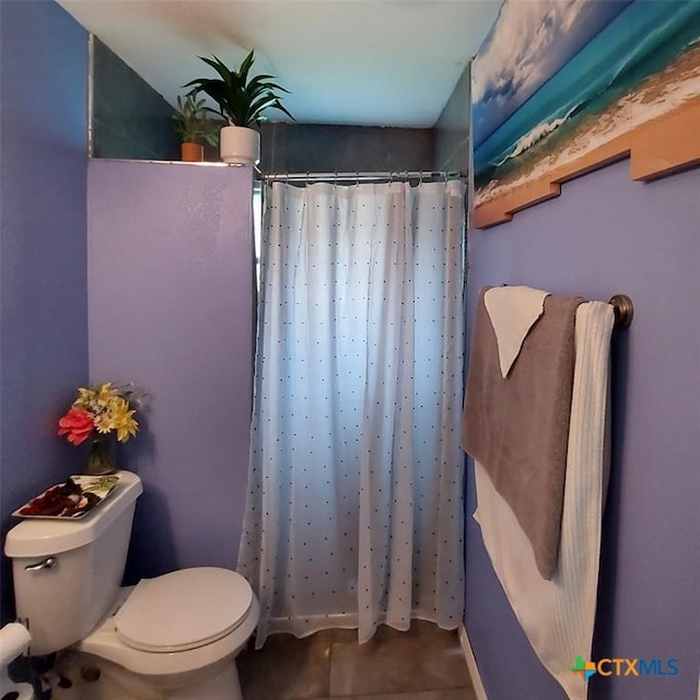 bathroom with a shower with shower curtain and toilet