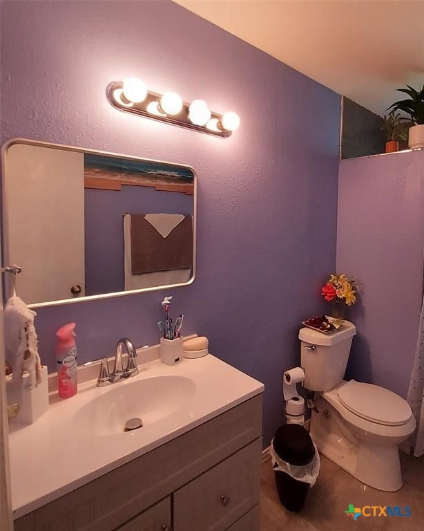 bathroom featuring toilet, vanity, and tile patterned floors