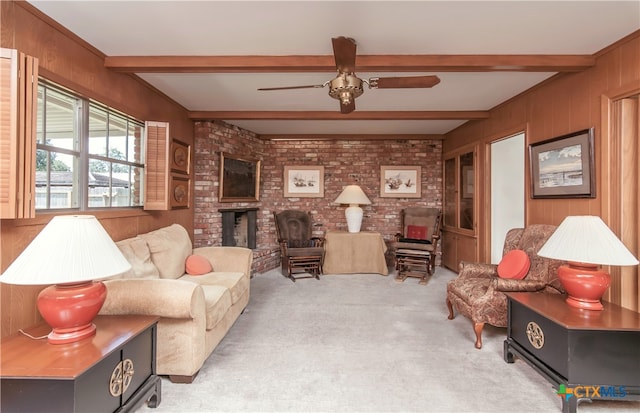 living room with beamed ceiling, wooden walls, and ceiling fan