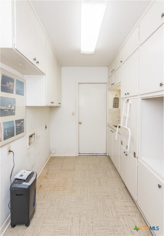 laundry room with hookup for an electric dryer and cabinets