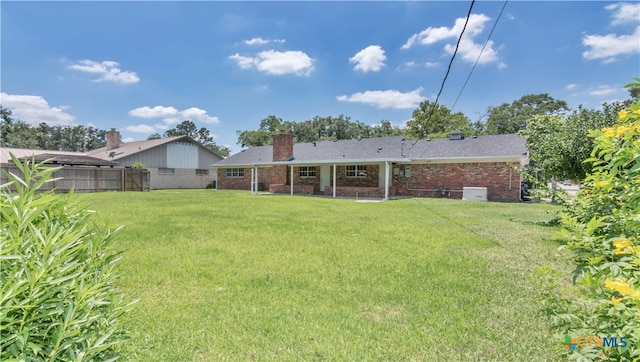 rear view of property featuring a yard