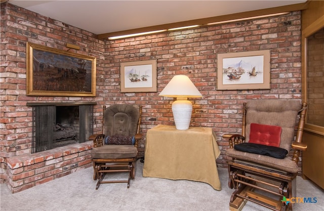 sitting room with carpet flooring, a fireplace, and brick wall