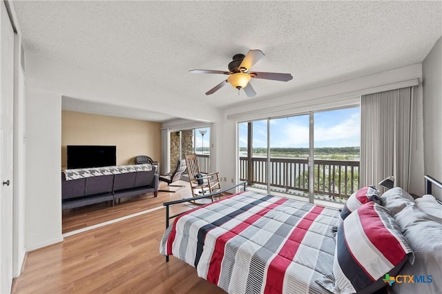 bedroom featuring baseboards, ceiling fan, light wood-style flooring, access to outside, and a textured ceiling