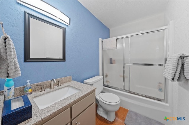 full bath featuring enclosed tub / shower combo, vanity, wood finished floors, and a textured wall