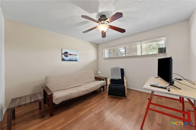 sitting room featuring a textured ceiling, wood finished floors, and a ceiling fan