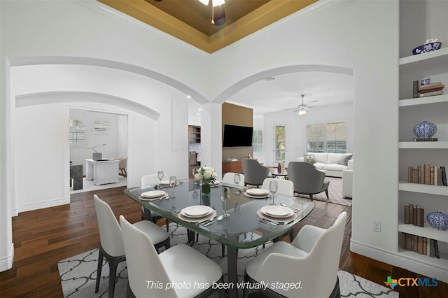 815 Lost Maples Trl, Georgetown, TX 78633 - dining area featuring a ceiling fan, built in shelves, arched walkways, wood finished floors, and baseboards
