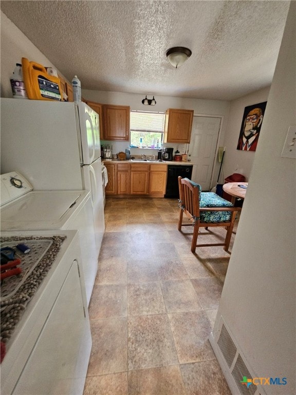 915 Dryden Ave, Copperas Cove, TX 76522 - kitchen with freestanding refrigerator, independent washer and dryer, light countertops, black dishwasher, and a textured ceiling