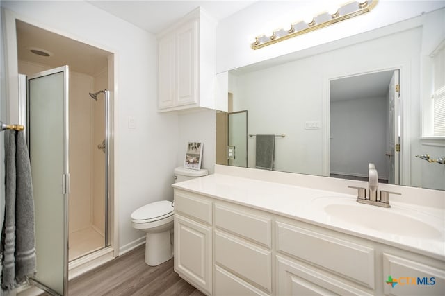 bathroom featuring hardwood / wood-style flooring, vanity, toilet, and walk in shower