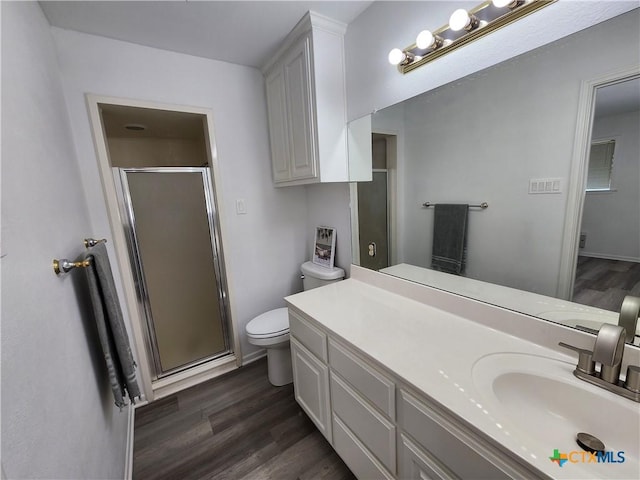 bathroom featuring vanity, hardwood / wood-style flooring, toilet, and a shower with shower door