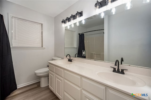 bathroom featuring toilet, vanity, a shower with shower curtain, and hardwood / wood-style flooring