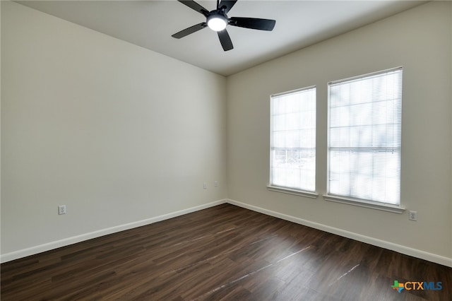 empty room with ceiling fan, baseboards, and dark wood-style flooring