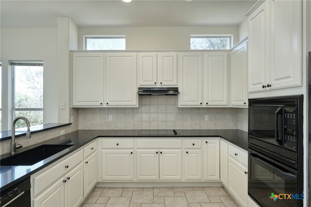 kitchen with a sink, black appliances, under cabinet range hood, dark countertops, and tasteful backsplash