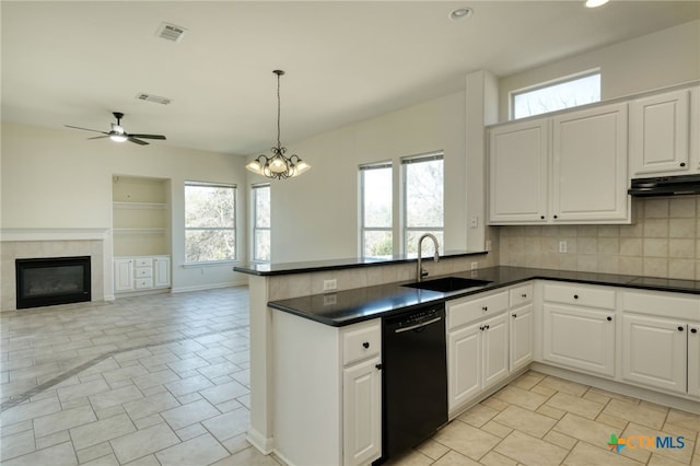 kitchen with visible vents, black appliances, a sink, dark countertops, and a peninsula